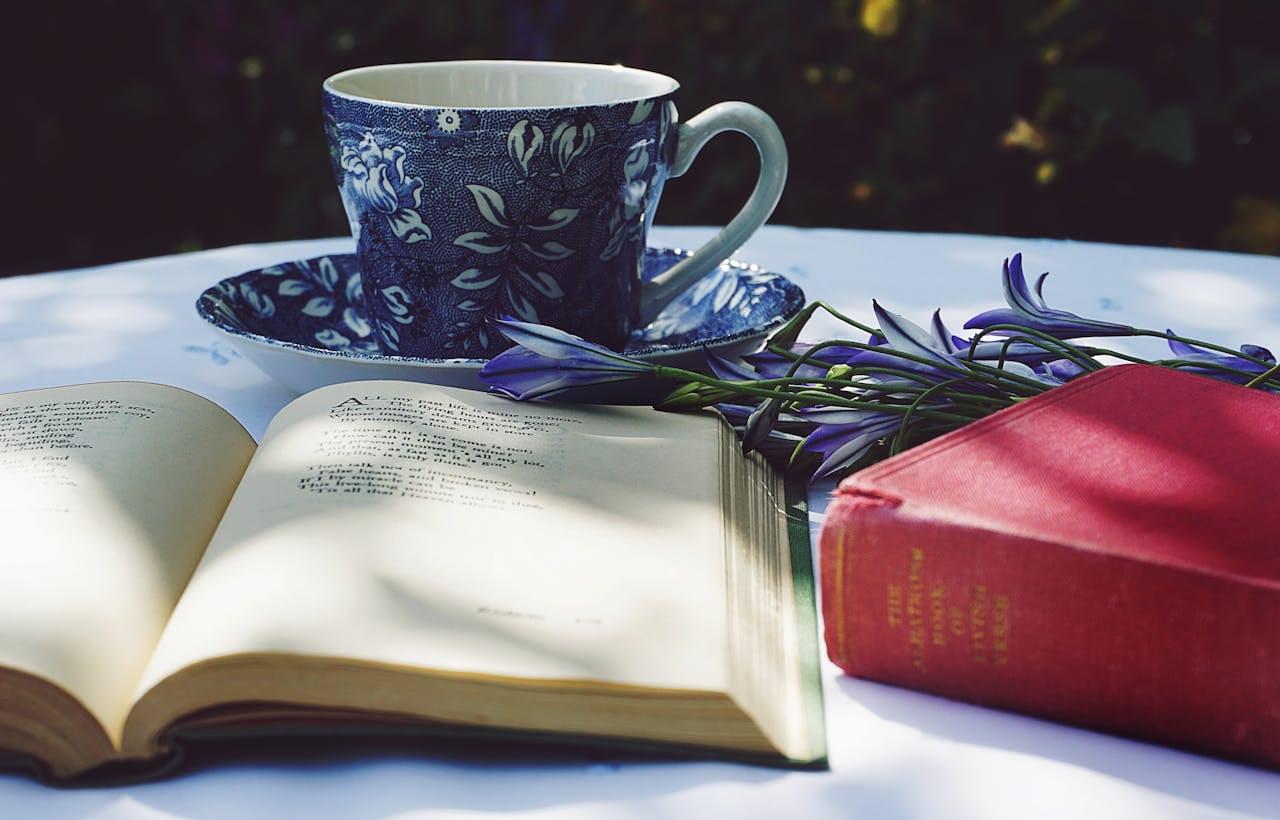 Чашка чая рядом с открытой книгой